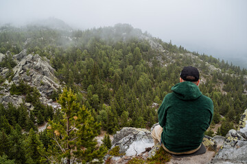 Naklejka premium A beautiful contemplation on a misty mountain offers a serene nature experience that captivates the soul and inspires outdoor adventure