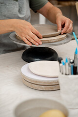 Creating ceramic products from flat sheets of clay. Using hands to model a form for a clay project. Building sides for clay products. Slab pottery.