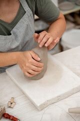 Removing air bubbles from clay before modeling to avoid the ruination of a ceramic product. Wedging the clay before starting making a pottery project to create proper consistency.