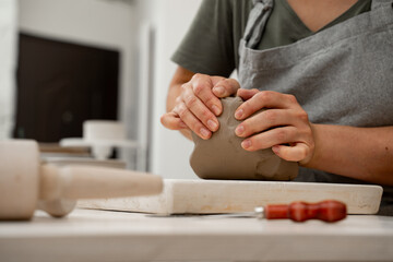 Removing air bubbles from clay before modeling to avoid the ruination of a ceramic product. Wedging the clay before starting making a pottery project to create proper consistency.