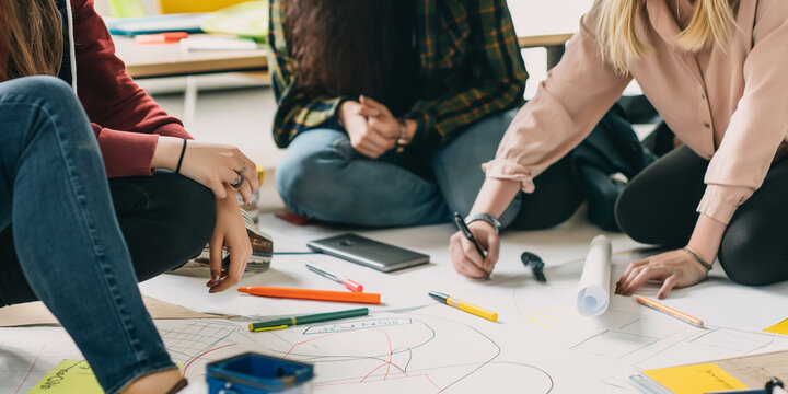 Collaborative Teamwork on Creative Project with Drawings, Charts, and Planning Materials