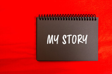 My story message written on black notebook page with red background. Conceptual my story symbol. Copy space.