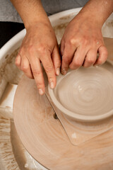 Creating a ceramic bowl by yourself in a pottery class. Wheel throwing. Learning how to model clay into different shapes with pottery wheel.