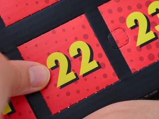 Woman hand ready to open the door with number 22 on the advent calendar.