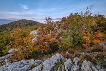 Beautiful quartz rocks in the embrace of colorful trees and hills. Autumn landscape, Slovakia, Tribec. Discover the beauty of the world. 