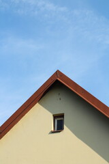 Red tiled roof with blue sky background
