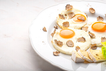 Black truffles gourmet  breakfast, brunch. Fried eggs recipe with black truffles and toast bread , white background. Internet banner, top view. Healthy recipe of Piedmont, Italy, Spain and France 