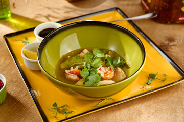 Delicious Shrimp Soup in Green Bowl with Fresh Cilantro Garnish on Yellow Plate