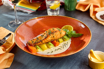 Gourmet Salmon Steak with Zucchini and Carrots on Elegant Plate in Vibrant Setting