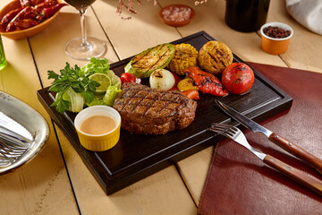Juicy Ribeye Steak with Grilled Vegetables on Wooden Board – Rustic Gourmet Cuisine