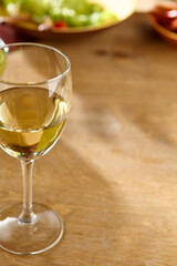 Elegant White Wine Glass on Rustic Wooden Table with Blurred Background