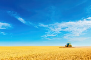 Naklejka premium A tractor working on a golden wheat field under a blue sky with fluffy clouds.