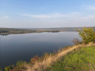 The bends of the Dniester River into the heights of sheer cliffs. Rocky area on the river bank. Deep ravine near the water