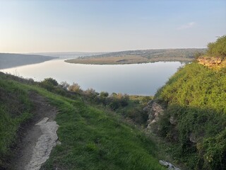 Obraz premium The bends of the Dniester River into the heights of sheer cliffs. Rocky area on the river bank. Deep ravine near the water