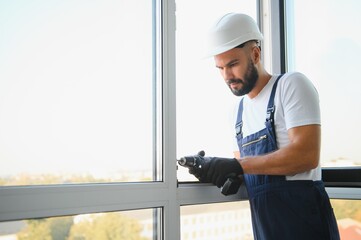 Construction worker installing window in house