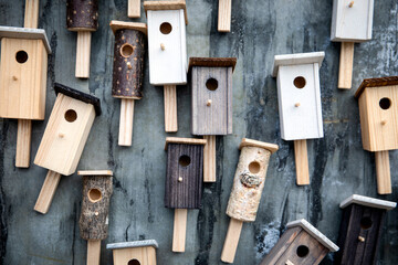 Many different wooden birdhouses on the wall, design elements