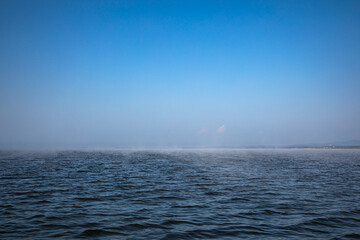 Fototapeta premium A vast body of water under a bright blue sky in the background