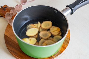 鍋に入れた生姜スライスと砂糖と水