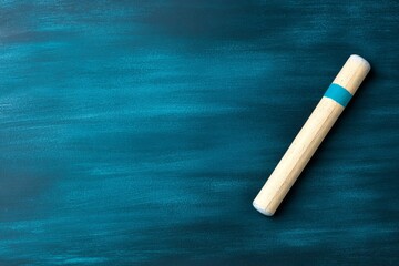 A single piece of chalk lying on a clean blackboard, representing the tools of teaching in a minimalistic style