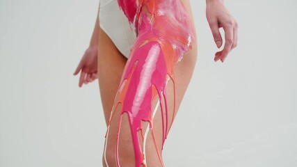Woman is drawing by colourful paints on her body close-up. Body art therapy with white colour paint. Many different paints on body