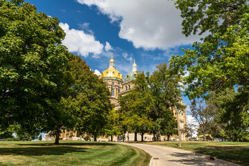 The Iowa state Capitol building on a hot late summer day with blue skies and clouds.  Des Moines, Iowa, USA.
