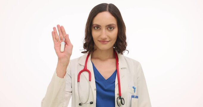 Lady physician shows tampon and sanitary pad on white background. Doctor explains importance of choosing right size based on individual menstrual flow levels