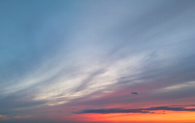 Beautiful sunset with soft clouds and vibrant colors illuminating the sky, creating a serene atmosphere. Ideal for nature lovers and travel enthusiasts.