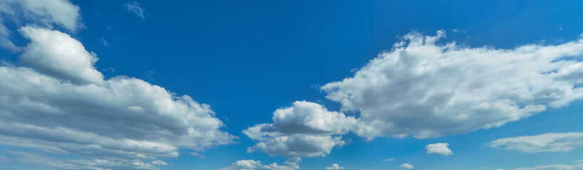 Fototapeta premium A serene sky with fluffy white clouds and a bright blue backdrop, capturing the essence of a beautiful day
