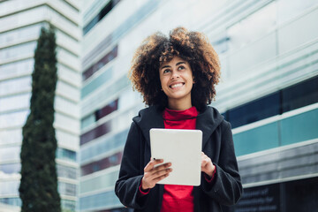 young African American business woman using digital tablet in city of Latin America, Hispanic...