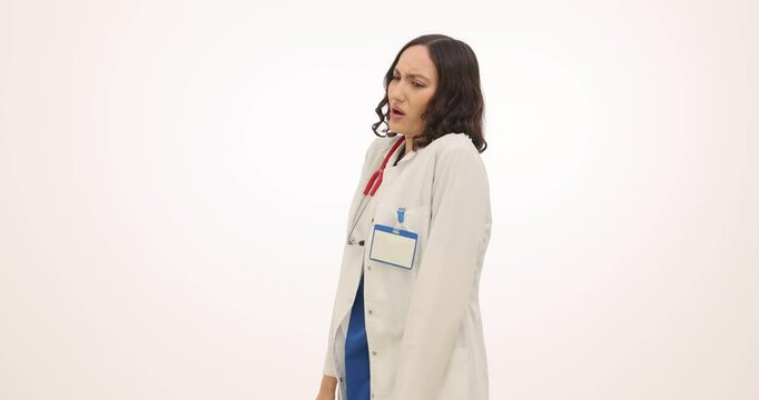 Woman physician grimaces wrinkling nose due to unpleasant smell on white background. Doctor in white coat shows aversion to nauseating smell