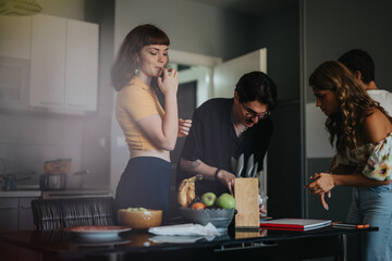 Group of friends enjoying a casual moment in the kitchen, preparing snacks and engaging in conversation. Warm atmosphere and a sense of camaraderie among young adults.