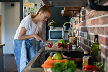 Young woman preparing fresh vegetables in a modern kitchen