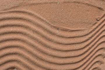 Lines drawn in brown sand background, beautiful sand texture, overhead view of chocolate brown sand, zen pattern drawn in the sand, Top view of fine grain texture