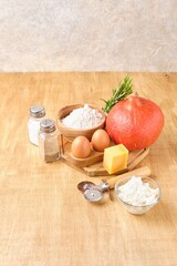 Prepared ingredients for ravioli with pumpkin and cheese on light wooden background. Recipes pumpkin.