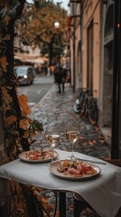 Fototapeta premium A table with two plates of food and two glasses of wine