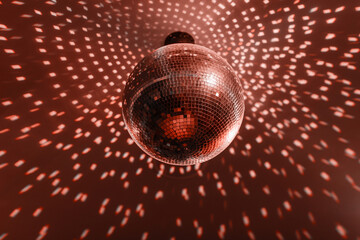 disco ball with mirror surface and bright rays, hanging on ceiling, night party background