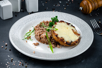 Dinner buckwheat with pork steak, cheese and herbs.