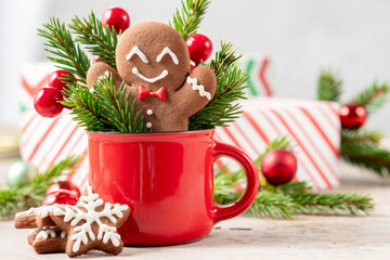 A red cup with a gingerbread man and snowflake cookies in it