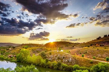 Duero River as it passes through the city of Soria with the sun setting at dusk giving golden...