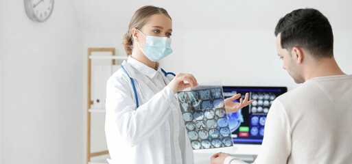 Female doctor showing x-ray scan to patient in clinic