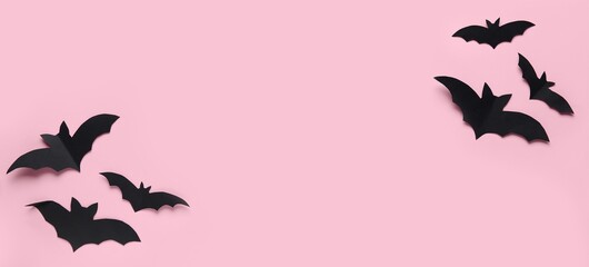 Black paper bats for Halloween party on pink background with space for text