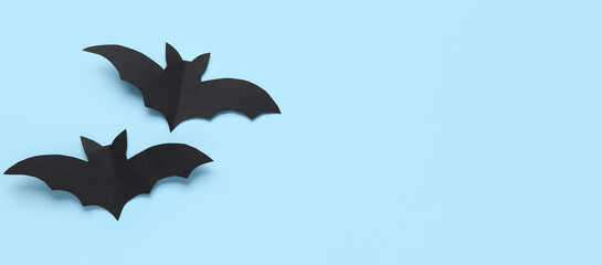 Black paper bats for Halloween party on blue background with space for text