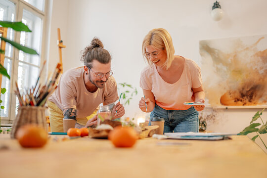 Creative painter couple at art studio painting with paintbrushes. - Powered by Adobe
