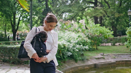 Woman carrying pet bag walking sunny park closeup. Lady enjoying calm weekend