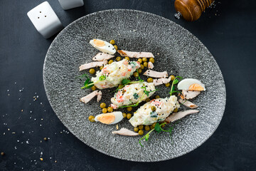 Salad Olivier from boiled potatoes, carrots, green peas, cucumbers, eggs, chicken ham and mayonnaise.