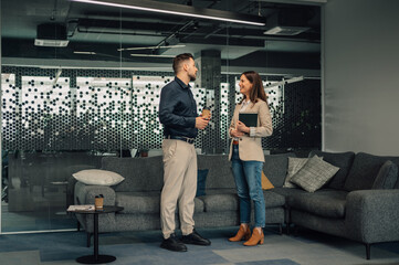 CEO standing with businesswoman at corporate office and discussing.