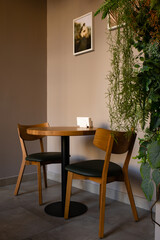 The interior of a modern restaurant in brown tones with a wooden table and chairs.