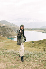 Naklejka premium a girl standing on the edge of a mountain and a lake behind her. Lake Gidget. Caucasus