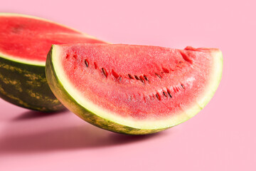 Half of fresh watermelon with piece on pink background