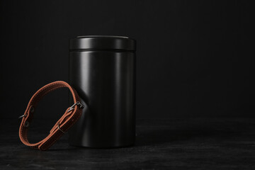 Mortuary urn and dog collar on dark background. Pet funeral